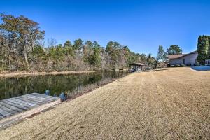 a large field next to a river with a house at Lovely Hot Springs Home with Lake Balboa Access in Hot Springs Village