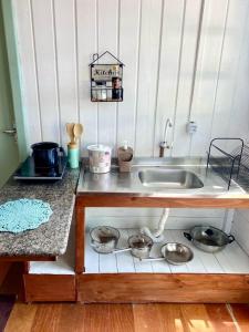 una cocina con fregadero y algunas ollas y sartenes en GREEN HOUSE - com linda vista para o mar, en Palhoça