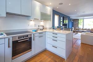 a kitchen with white cabinets and a stove top oven at Clearwater 67, Ortolan Villa P in Somerford Keynes