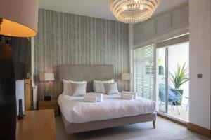 a bedroom with a large bed and a large window at Clearwater 67, Ortolan Villa in Somerford Keynes +21 photos