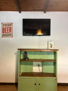 a green cabinet with a television on a wall at Cabañas Los Coihues in San Carlos de Bariloche