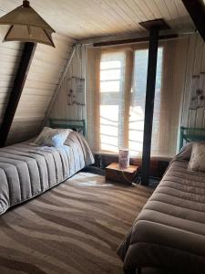 Un dormitorio con una cama grande y una ventana en Cabañas Los Coihues en San Carlos de Bariloche