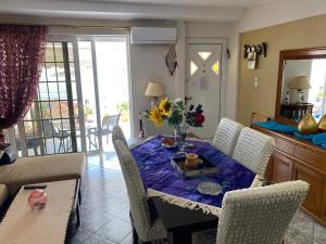 une salle à manger avec une table, des chaises et des fleurs. dans l'établissement Two Islands, à Pákhi