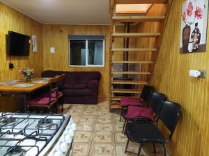 uma sala de estar com um fogão, uma mesa e cadeiras em Cabañas Nelly em Frutillar