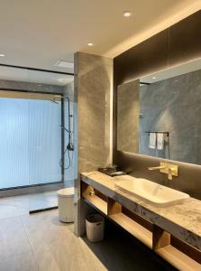 a bathroom with a sink and a mirror at Looma Private Pool Villas in Pantai Cenang