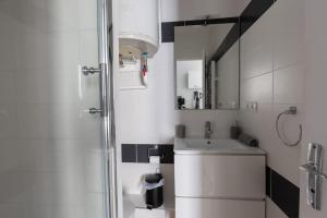 ein weißes Badezimmer mit Waschbecken und Dusche in der Unterkunft L'appart K-ractère- City, cosy et design pour 4 pers in Le Mans + 31 Fotos