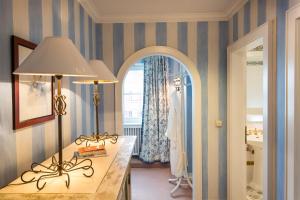 a room with a table with two lamps and a mirror at Hotel Edelweiss in Zürs am Arlberg