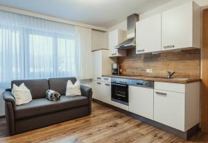 a living room with a couch and a kitchen at Gästehaus Eder in Sankt Martin am Tennengebirge