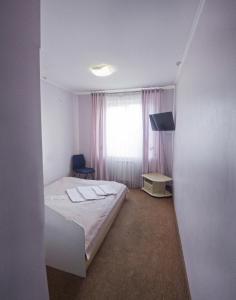 mały pokój z łóżkiem i oknem w obiekcie Motel w Iwano-Frankiwsku