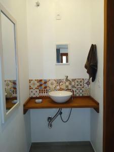 a bathroom with a sink and a mirror at Recanto das Amendoeiras in Guarda do Embaú