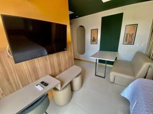 Habitación con cama, TV y sofá. en Edifício SKY Apto 716 - ER Hospedagens, en Maceió