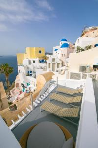 a view of a balcony with chairs and buildings at Vogue Suites in Oia