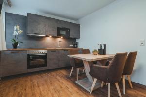 a kitchen with a wooden table and some chairs at Gästehaus Eder in Sankt Martin am Tennengebirge