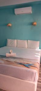 a bed with pink sheets and pillows in a room at Hotelito Villas Holbox in Holbox Island