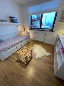 a bedroom with a bed and a table and a window at Apartament Poleczka Zakopane Kościelisko in Zakopane