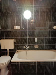 a bathroom with a toilet and a bath tub at Apartamenty blisko Manufaktury in Łódź +52 photos