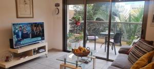 a living room with a flat screen tv and a couch at A Dream Place in Raanana, up to 5 guests - Swimming Pool - Jacuzzi & Gym in Ra‘ananna