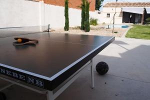 una mesa de ping pong con una pelota de tenis. en Villa Mandrés. Casa con jardín y piscina. Proximo a Puy Du Fou., en Totanés
