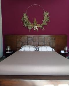 - une chambre avec un grand lit et un mur pourpre dans l'établissement CALME ET SERENITE A LA RIVIERE, à Saint-Louis