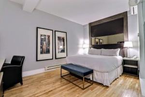 a bedroom with a large bed and a chair in it at St. James' Gate, Boutique Hotel in Moncton