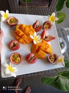 un plato blanco con fruta y fruta de la pasión. en CALME ET SERENITE A LA RIVIERE, en Saint-Louis