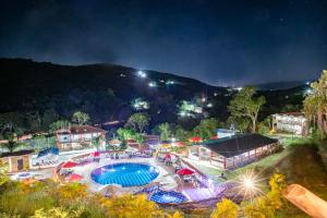 a resort with a swimming pool at night at Hotel Verde Menta in San Gil