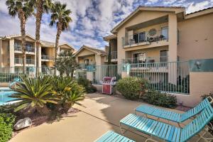 a apartment complex with blue benches and palm trees at Laughlin Mtn Getaway 2 Mi to Colorado River in Laughlin