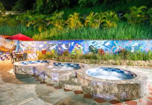 a patio with three jacuzzi pools in front of a wall at Hotel Verde Menta in San Gil