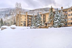 a large building in the snow with trees in front of it at Remodeled Vail Condo with Hot Tub Access! in Vail