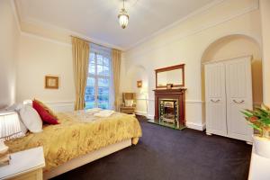 a bedroom with a bed and a fireplace at Southgarth Apartments by Week2Week in South Shields
