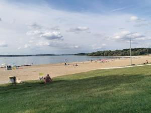 a group of people on a beach with a body of water at La villa du lac à Mesnil Saint Père in Mesnil-Saint-Père