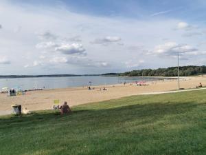 grupa ludzi na plaży z zbiornikiem wody w obiekcie La villa du lac à Mesnil Saint Père w mieście Mesnil-Saint-Père