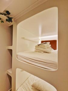 a white room with white towels on a shelf at Hostel The Golden Stork in The Hague