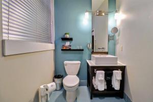 a bathroom with a white toilet and a sink at St James Gate by Bower Boutique Hotels in Moncton