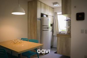 cocina con mesa y nevera en Qavi - Apartamento no Centro de Pipa #SolarÁgua162, en Pipa