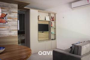 sala de estar con sofá y TV en la pared en Qavi - Apartamento no Centro de Pipa #Solar163, en Pipa
