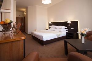 ein Hotelzimmer mit einem Bett und einem Tisch in der Unterkunft Restaurant Pensiune Bucovina in Câmpulung Moldovenesc
