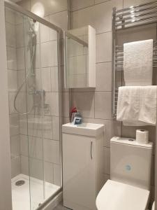 een witte badkamer met een douche en een toilet bij New - Cosy London studio in quiet street near parks 1071gr fl in Londen