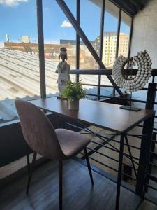 a table and a chair in a room with a window at 353 Maboneng on Craft in Johannesburg