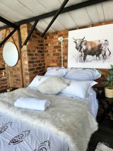 uma grande cama branca com almofadas e uma imagem de uma vaca em 353 Maboneng on Craft em Joanesburgo