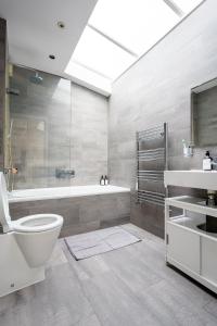 La salle de bains est pourvue d'une baignoire, de toilettes et d'un lavabo. dans l'établissement Immaculate 3-Bed House in central London, à Londres