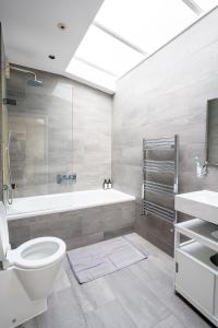 La salle de bains est pourvue d'une baignoire, de toilettes et d'un lavabo. dans l'établissement Immaculate 3-Bed House in central London, à Londres