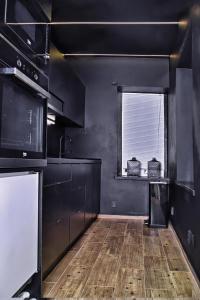 una cucina con pareti nere e pavimenti in legno di Wellness Gallery Apartments a Liberec