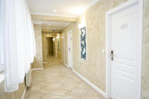 a hallway with a white door and tile floors at Роял Шумен in Shumen
