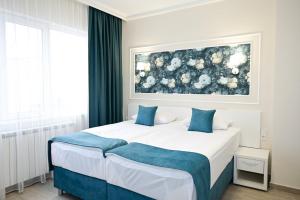 a bedroom with a bed and a painting on the wall at Роял Шумен in Shumen