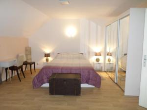 ein Schlafzimmer mit einem Bett mit einer lila Tagesdecke in der Unterkunft MOULIN DE L'ABBESSE in Thouars