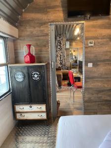 een kamer met een dressoir met een rode vaas erop bij Gleis 2, Waggon mit Ofen, Whirlpool und Sauna in Dahlem