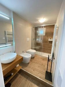 un bagno con due lavandini, un water e una doccia di Casetta di Gaia a Monopoli