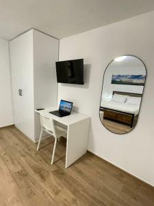 una camera con scrivania bianca e specchio di Casetta di Gaia a Monopoli