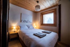 een slaapkamer met een bed met twee handdoeken erop bij Chalet vue Mont-Blanc, +4 Chambres, cheminée in Megève